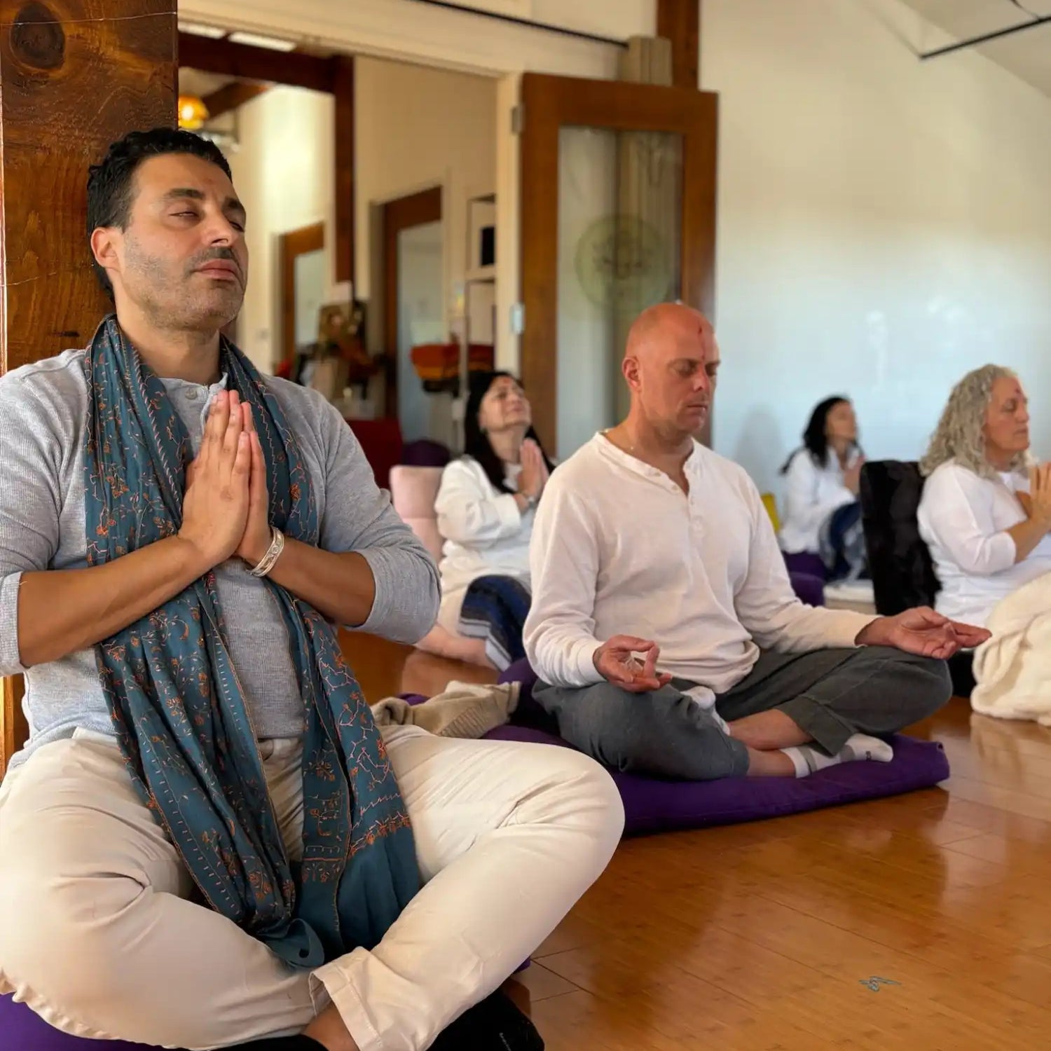 Group meditating indoors.