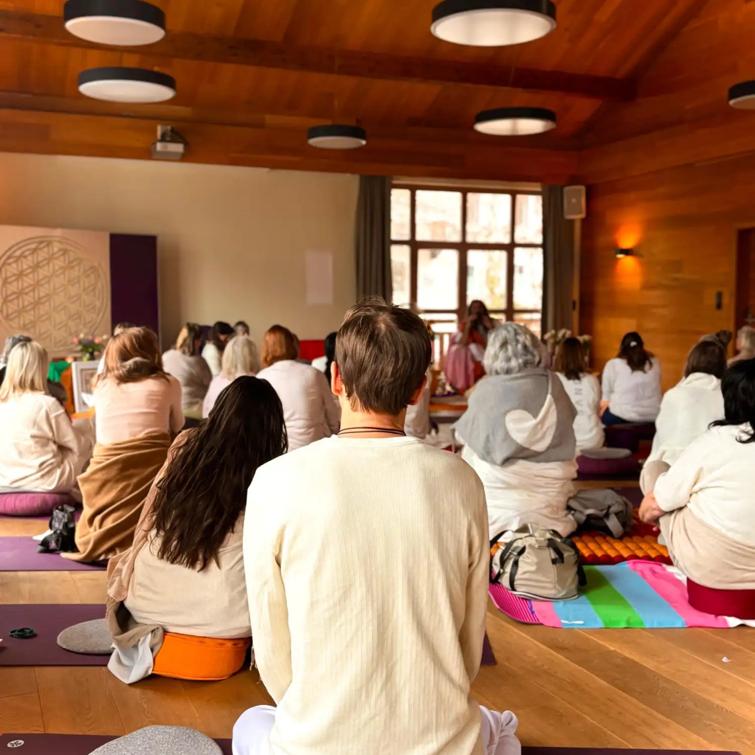 A purple yoga mat with a textured surface and rounded edges, placed on wooden flooring.